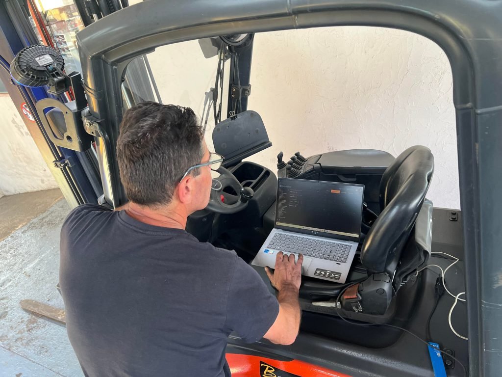 Mécanicien réalisant le diagnostic électronique d'un chariot élévateur